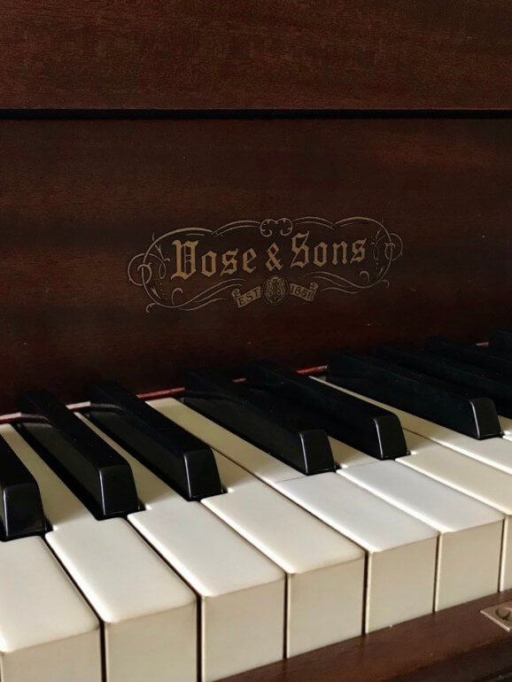 Close-up of a beautiful piano keyboard with glossy white and black keys shining under soft light, ready for a piano lesson.